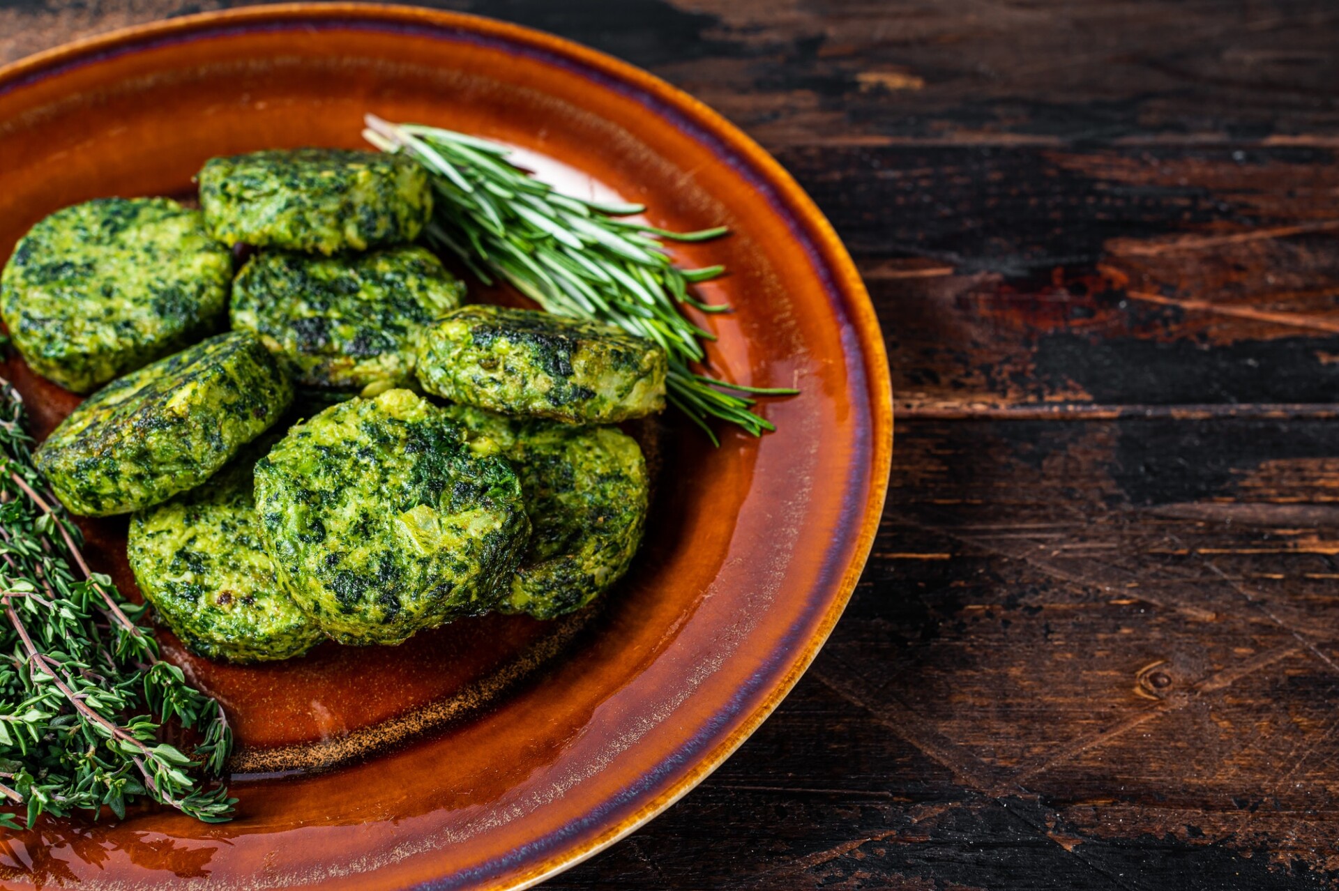 Fried vegetarian broccoli vegetable burgers patty on a rustic plate. Dark wooden background.